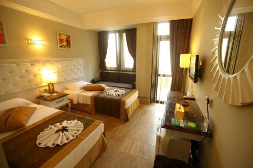 a hotel room with two beds and a couch at Telmessos Select Hotel - Adult Only (+16) - All Inclusive in Oludeniz