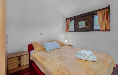 a bedroom with a bed with two towels on it at 3 Bedroom Gorgeous Home In Blazevci in Blaževci