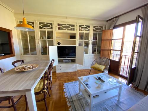 uma sala de estar com uma mesa e uma televisão em Apartamento Horia em Viana