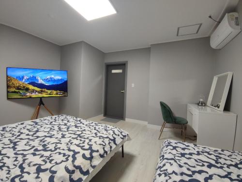 um quarto com uma cama e uma televisão na parede em Aha Stay em Gyeongju