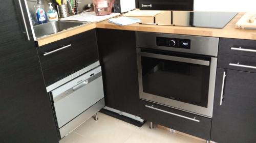 une cuisine avec une cuisinière, un évier et un micro-ondes dans l'établissement A la Tour des Rohan, à Strasbourg