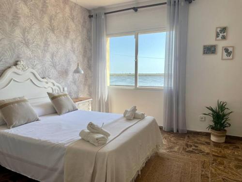 a bedroom with a white bed with towels on it at El Mirador: Un lugar único en el Corazón del Delta in Els Muntells