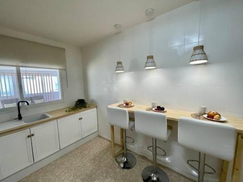 a kitchen with white cabinets and a counter with a sink at El Mirador: Un lugar único en el Corazón del Delta in Els Muntells