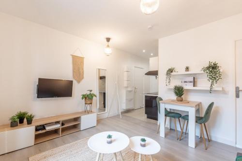 un salon avec une télévision, une table et des chaises dans l'établissement Sweethost - L'Amazone - T2 Proche Gare & Disneyland, à Lagny-sur-Marne