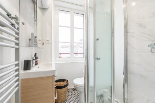 uma casa de banho com um WC e uma cabina de duche em vidro. em Sweethost - L'Amazone - T2 Proche Gare & Disneyland em Lagny
