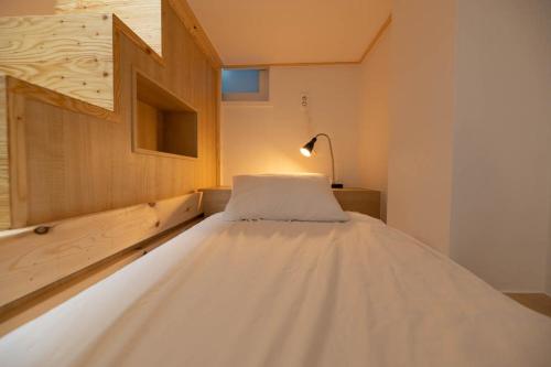 a large white bed in a room with a lamp at Aha Stay in Gyeongju