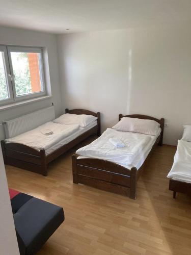two beds in a room with two windows at Ubytovňa Kriváň in Važec