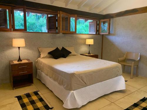 una camera con un letto con due lampade e una sedia di Retiro com lareira em frente à reserva ambiental a Carapicuíba