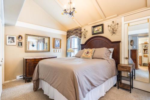 1 dormitorio con 1 cama grande y espejo en Camp Cottonwood, en Teton Village