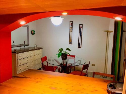 uma sala de jantar com uma mesa com cadeiras vermelhas e uma cozinha em Espaço gourmet e home-office na Granja em São Paulo