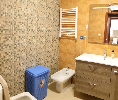 a bathroom with a toilet and a blue trash can at Arco Mediterráneo chalet independiente in Torrevieja