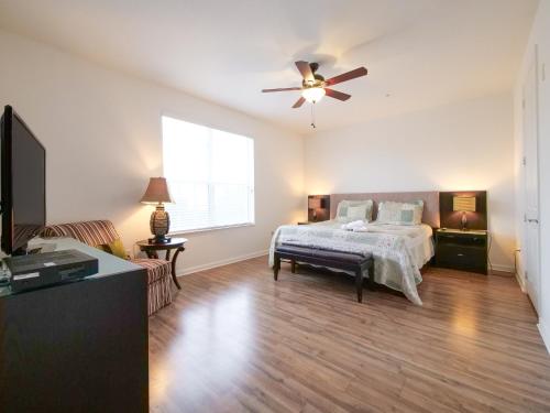 - une chambre avec un lit et un ventilateur de plafond dans l'établissement 4Br 2Bath Condo Balcony 5min Conv Center 2020ft, à Orlando