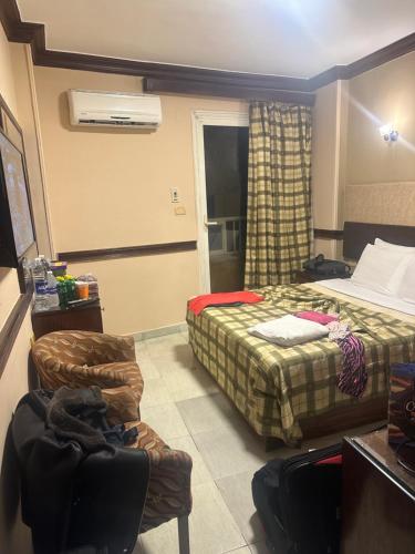 een hotelkamer met 2 bedden en een stoel bij Smouha Pardise in Alexandrië