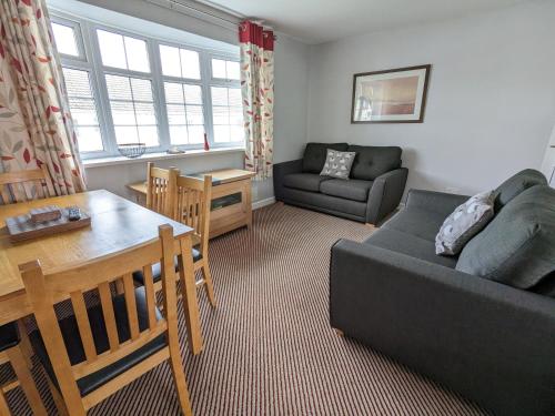 a living room with a couch and a table at 35 Gower Holiday Village in Reynoldston