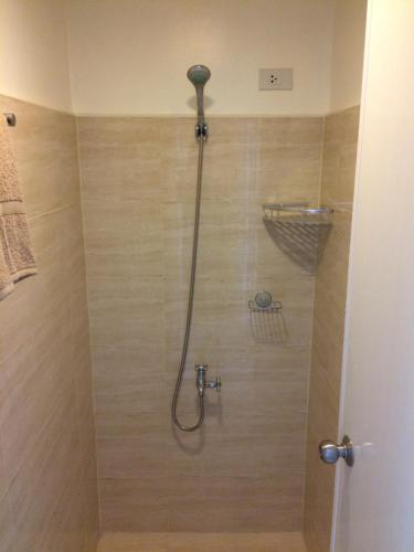 a shower with a shower head in a bathroom at Mabolo Garden Flats in Cebu City
