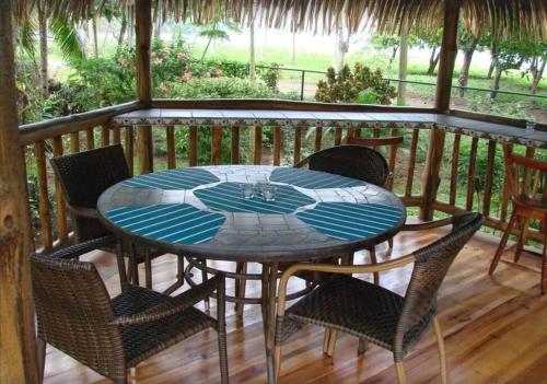 a glass table and chairs on a porch at Casa Sammie: True Costa Rica in Tárcoles