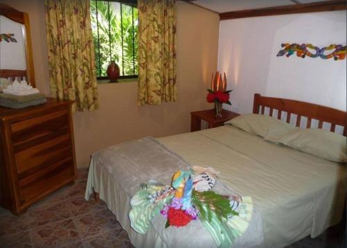 a bedroom with a bed and a dresser and a window at Casa Sammie: True Costa Rica in Tarcoles