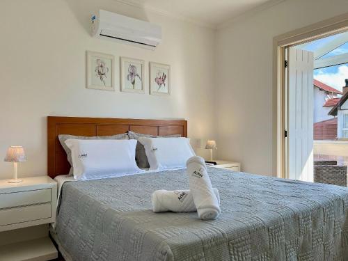 グラマドにあるApto 2dorm 500m Rua Coberta by Achei Gramadoのベッドルーム1室(靴1足付きのベッド1台付)