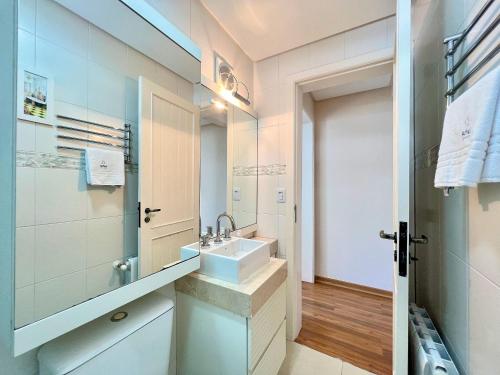 グラマドにあるApto 2dorm 500m Rua Coberta by Achei Gramadoの洗面台と鏡のあるバスルーム