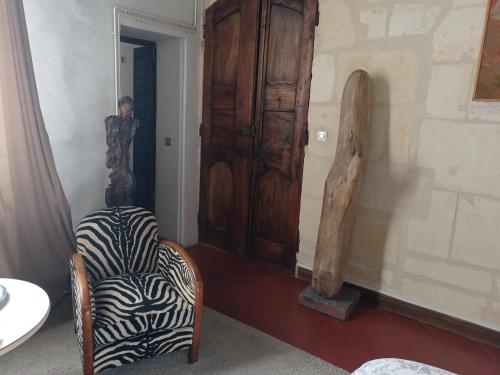 Cette chambre dispose d'une chaise et d'une porte en bois. dans l'établissement Ô Anges, à Arles