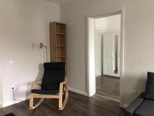 - une chaise noire dans le salon avec un miroir dans l'établissement Quattro Casa, à Sopron