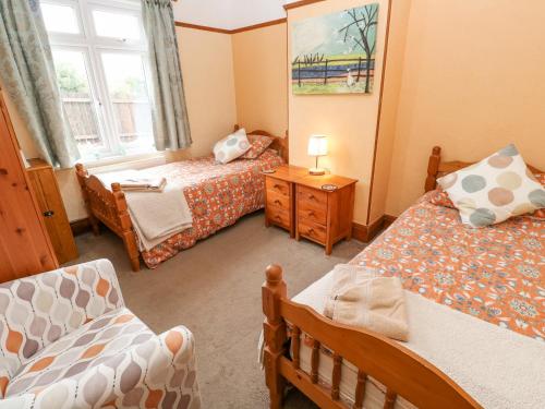 Habitación pequeña con 2 camas y ventana en Trelydarth en St. Agnes 