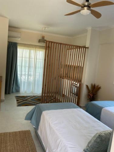 a bedroom with two beds and a ceiling fan at Nereides Suites in Agios Gordios