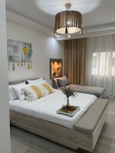 a bedroom with a large bed with a potted plant on it at Studio SvEt in ParC Mohammedia in Mohammedia