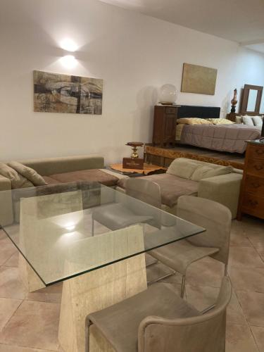 a living room with a glass table and a bed at La Tana di Ghino di Tacco in Sinalunga