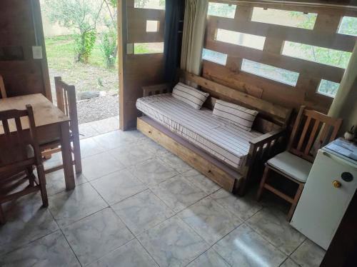 un banco en una habitación con mesa y sillas en Cabaña de Montaña en Luján de Cuyo
