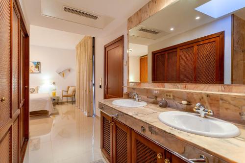 a bathroom with two sinks and a large mirror at Zen Villa Anfi Tauro Golf Meer Pool in Mogán