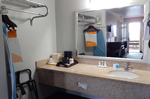 a bathroom with a sink and a large mirror at Quality Inn Siloam Springs West in Siloam Springs