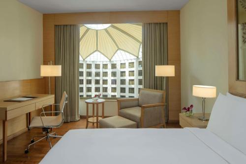 a hotel room with a bed and a desk at Radisson Blu Hotel New Delhi Dwarka in New Delhi