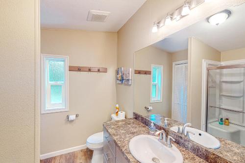a bathroom with a sink and a toilet and a mirror at Wygant Road Retreat in Coos Bay