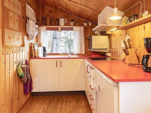 een keuken met een rood aanrecht en een wastafel bij 6 person holiday home in Gedser in Gedser