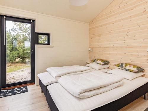 a room with four beds in it with a window at Holiday home Væggerløse CCXVII in Bøtø By