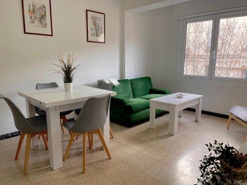 een woonkamer met een groene bank en een tafel bij Apartamento estación de Portbou in Portbou