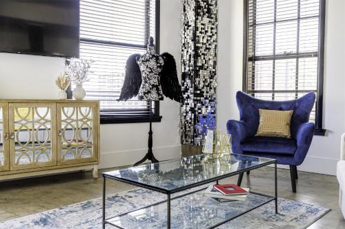 Urban Loft Apartment في لوس أنجلوس: غرفة معيشة بها كرسي ازرق وطاولة زجاجية