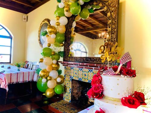 a table with a cake and balloons and a fireplace at Hotel Museo Mayan Inn in Chichicastenango