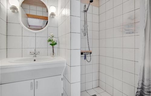 uma casa de banho branca com um lavatório e um espelho em 4 Bedroom Lovely Home In Blvand em Blåvand
