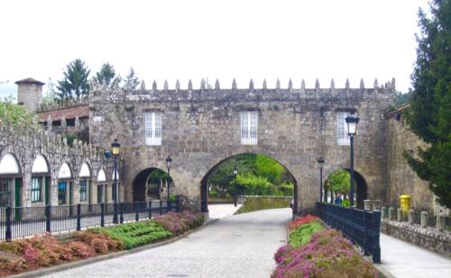 un antiguo edificio de piedra con un arco en un parque en Piso bonito con vistas Negreira en Negreira