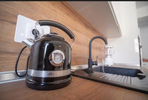 a black tea kettle sitting on a kitchen counter at Apartman San in Posušje