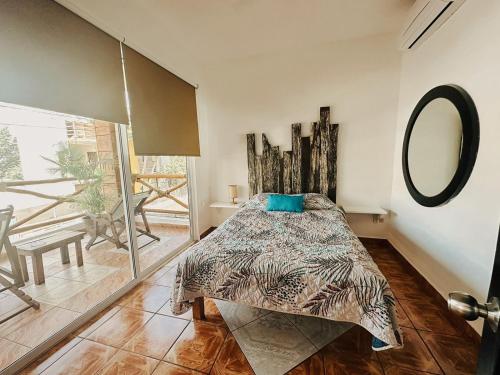 a bedroom with a bed and a mirror on the wall at Hotel Nicte Ha Tulum in Tulum