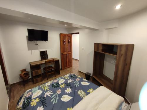 1 dormitorio con 1 cama y TV en la pared en linda house cusco, en Cusco