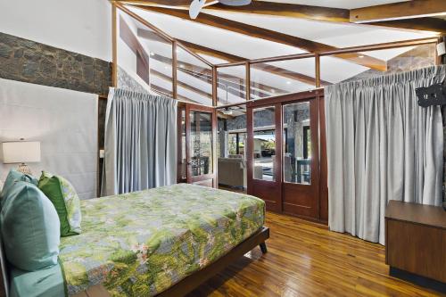 a bedroom with a bed and a couch in it at Playa Potrero - beachfront Villa, big private pool - Casa Bella Catalina in Potrero