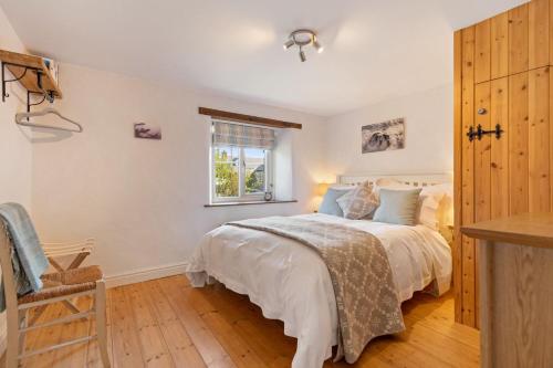 a bedroom with a bed and a window at Summerhill Cottage in Mathry
