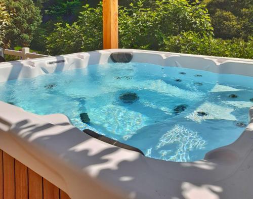 uma banheira de hidromassagem com água azul em Villa Saint Kirio - piscine et spa em Morlaix