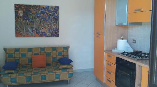 una cocina con sofá en la esquina de una cocina en Appartamento a 200MT da "La Pelosa", en Stintino