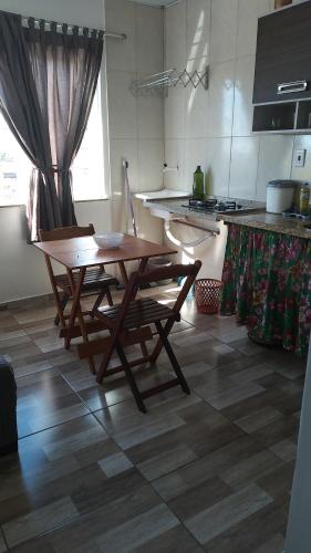 uma cozinha com uma mesa de madeira e 2 cadeiras em Hospedaria Ilhéus 03 em Ilhéus
