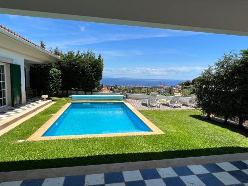 a swimming pool in the yard of a house at Casa Roc Madeira - 5 Bedrooms - Ocean and City Views - Private Heated Pool in Funchal